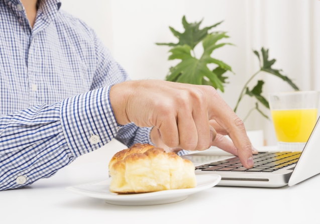 businessman-typing-laptop-with-bread-glass-juice-table